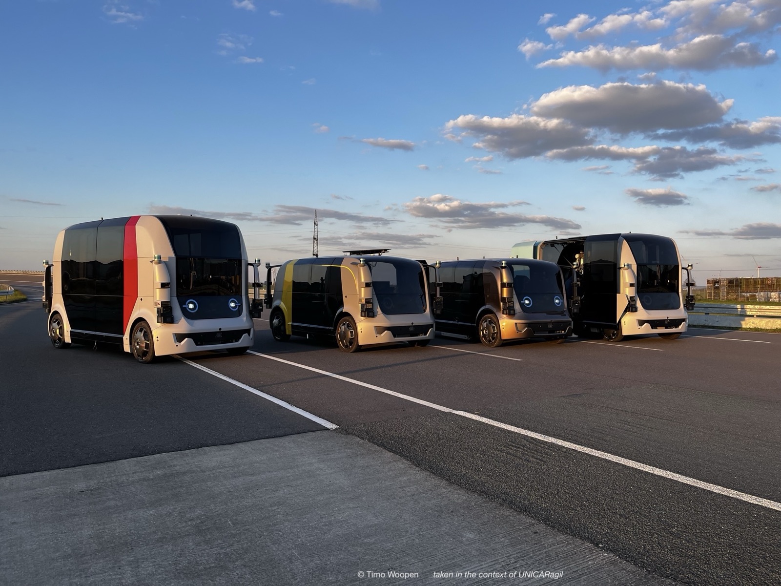 A fleet of autonomous vehicles staged on a test track at sunset.